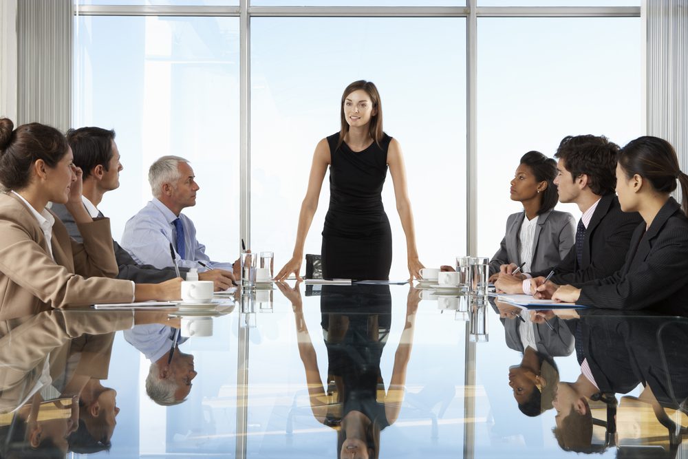 Group of professionally dressed people around a boardroom table