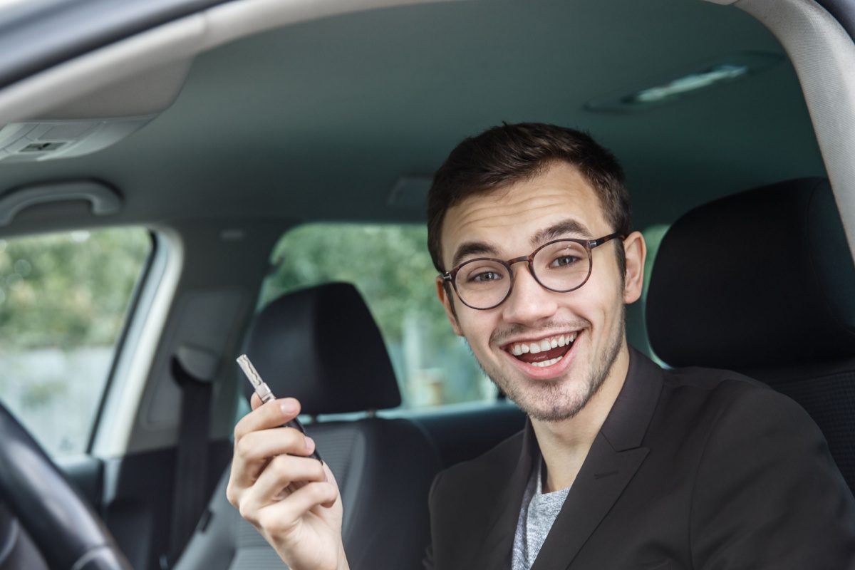 Gig worker uber driver in car holding phone smiling